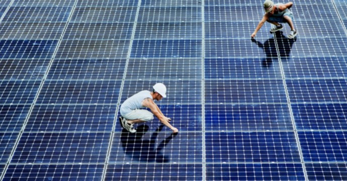 High angle view of two construction workers standing on solar panels