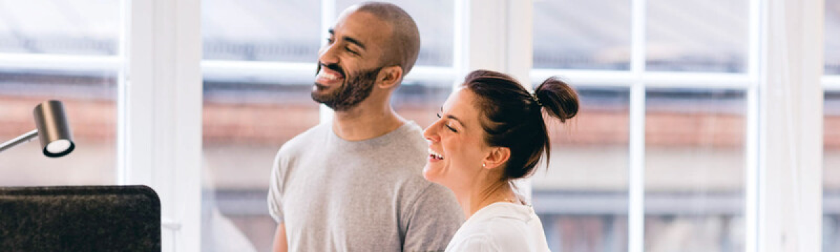 Male and female colleagues working together at a stand up desk in an office