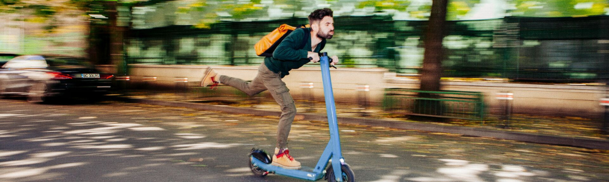 Man riding a scooter passing by in speed