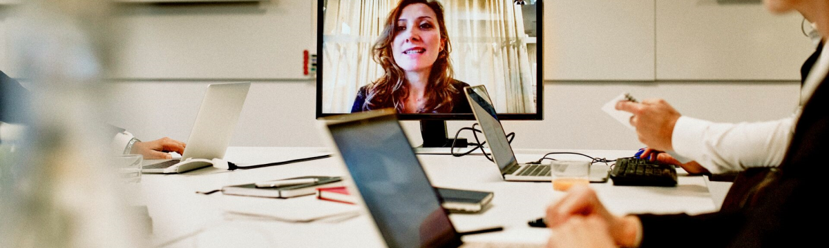 Hybrid business meeting with colleagues both in person and virtually in an office room